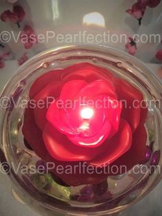 a red candle in a glass jar filled with water