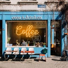 an outdoor cafe with chairs and tables in front of it that has neon coffee written on the window