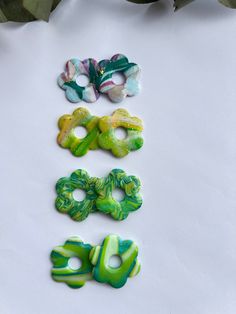 four pieces of glass sitting on top of a white surface next to green and purple flowers