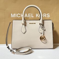 New With Tag Michael Kors Sheila Medium Satchel Shoulder Crossbody Bag Vegan Leather Light Cream 100% Authentic Retail: $558.00 Plus Tax **Please See The Measurement For The Size** No Dust Bag Michael Kors Logo At Front Gold Toned Hardware 1 Mk Charm Zip Top Closure Triple Compartment With Center Zip Custom Fabric Lining 1 Zipper Pocket 1 Slip-In Pocket 11"(Top) 12"(Bottom) (L) X 8.5"(H) X 4"(D) Straps: 4" Adjustable Strap: 20.25"-23.75" Very Clean, Smoke-Free And Pet-Free Environment Michael Kors White Shoulder Bag With Branded Hardware, White Michael Kors Shoulder Bag With Branded Hardware, Michael Kors White Shoulder Bag With Detachable Strap, Classic White Satchel With Branded Hardware, White Michael Kors Shoulder Bag With Detachable Strap, Michael Kors White Bag With Detachable Handle, White Michael Kors Bag With Detachable Handle, White Leather Satchel With Branded Hardware, Michael Kors Cream Shoulder Bag With Detachable Handle