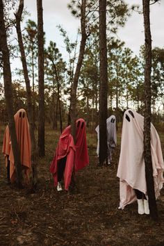 three ghostly people standing in the woods with their faces covered by blankets and covering them