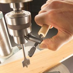 a person using a drill to cut wood