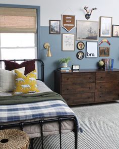 a bedroom with blue walls and pictures on the wall