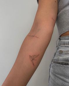 a woman's arm with a small tattoo on it