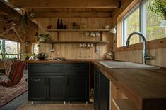 a kitchen with wood paneling and black cabinets