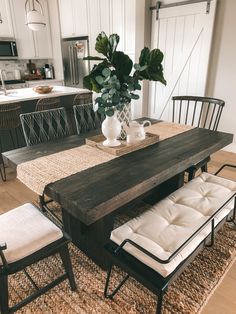 a dining room table with two chairs and a bench in front of it on top of a rug