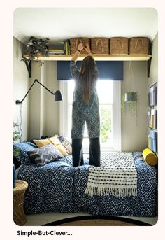 a woman standing on top of a bed next to a window