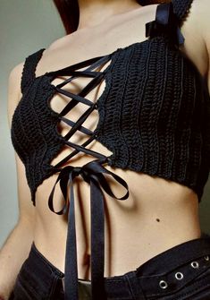 a close up of a person wearing a black top with laces on it's back