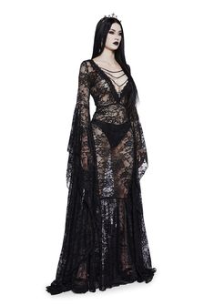 you’re a Victorian splendor in the shadows. This maxi dress has a lace construction, a v-neckline with chain detail and dangling cross charm, long floor-length flare sleeves, and side zipper closure. Black Gothic Long Dress, Gothic Black Dress Long, Black Lace Gothic Dress, Black Gothic Dress Long, Long Lace Black Dress, Goth Victorian Dress, Black Lace Dress With Sleeves, Gothic Dress Elegant, Goth Lace Dress