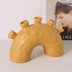 a ceramic animal shaped vase sitting on top of a table next to a magazine holder