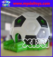 a large soccer ball sitting on top of green plastic blocks in front of a blue background