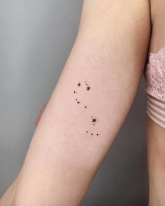 a woman's arm with small stars on the left side of her right arm