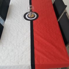 a red and white table cloth on top of a dining room table with black chairs