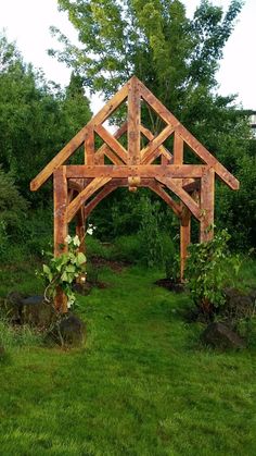 a wooden structure sitting on top of a lush green field