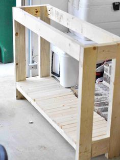 a kitchen island made out of pallet wood with a sink in the back ground