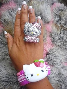 a woman's hand with two hello kitty rings on it