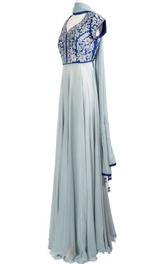 An elegant cool blue chiffon Anarkali drapes beautifully across the body and stands out with a raw silk royal blue top with tonal thread and zari embroidery.Length: 63Fabric: Top - Raw Silk, Gown / Dupatta - ChiffonEmbroidery: Thread, Stone Silk Blue Anarkali Set For Navratri, Elegant Blue Anarkali Set With Cutdana, Blue Georgette Anarkali Set With Cutdana, Blue Raw Silk Churidar For Navratri, Silk Churidar With Traditional Drape For Reception, Blue Silk Churidar For Navratri, Blue Georgette Anarkali Set With Traditional Drape, Blue Floor-length Traditional Wear For Transitional Season, Blue Transitional Traditional Floor-length Wear