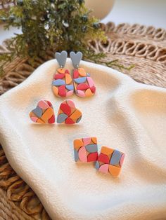 three pieces of colorful paper are sitting on a white towel next to a potted plant