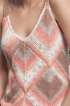 a close up of a person wearing a knitted tank top with an open back