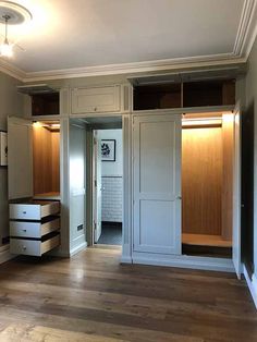 an empty room with wooden floors and closets