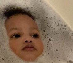 a baby is sitting in the bathtub with bubbles