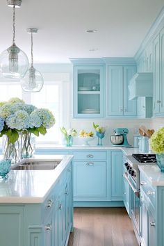 a kitchen filled with blue cabinets and white counter tops next to a stove top oven