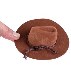 Mini Brown Flocked Cowboy Hat. This Small Brown Flocked Cowboy Hat is a great accessory for displaying with various western decor and fashioning with small dolls and stuffed animals.    The cowboy hat is covered in brown velveteen coating and its crown is detailed with rope trim. This small cowboy hat makes for a darling placeholder or favor for western-themed, events, barbecues, and weddings.    Made of felt, plastic, and polyester. Brown Mini Hats With Flat Brim For Country Events, Brown Flat Brim Mini Hat For Country Events, Brown Mini Hat With Short Brim For Rodeo, Country Style Brown Mini Hats With Curved Brim, Country Style Mini Hat With Curved Brim In Brown, Brown Short Brim Mini Hat For Rodeo, Western Style Brown Wide Brim Mini Hat, Western Style Wide Brim Mini Hat In Brown, Brown Cap Felt Hat For Rodeo