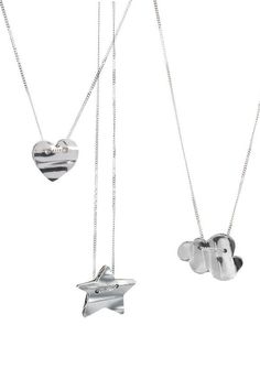 three silver necklaces with hearts and an elephant hanging from the back, on a white background