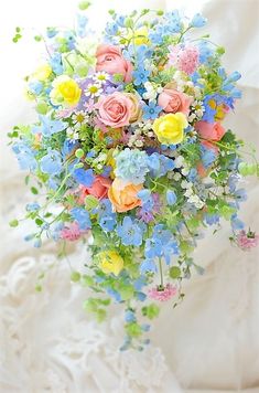 a bridal bouquet with blue, yellow and pink flowers