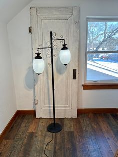 two lamps are on the floor in front of a door