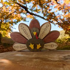 a wooden turkey sitting on top of a rock