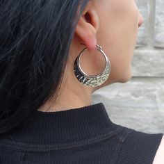 We love these silver beauties. The large size of the hoops makes a bold statement, ensuring you stand out with every wear. Made from top-quality sterling silver, each hoop is meticulously hand-hammered to create a unique textured surface. The hammered finish not only adds a touch of artisanal charm but also catches the light in a way that beautifully accentuates the crescent shape. 925 Sterling Silver Hammered finish Approx. 1.6" L x 1.4" W 8 grams Handcrafted in Taxco, Mexico Small Hammered Metal Hoop Earrings, Everyday Metal Hoop Earrings With Oxidized Finish, Elegant Hammered Sterling Silver Hoop Earrings, Metal Hoop Earrings With Shiny Finish, Silver Hammered Hoop Jewelry, Silver Hammered Sterling Silver Hoop Earrings, Everyday Hammered Metal Hoop Earrings, Hammered Sterling Silver Hoop Earrings In Silver, Modern Silver Hammered Hoop Earrings