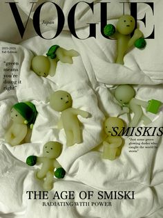 a magazine cover with some small plastic animals on top of white sheeted paper and green leaves