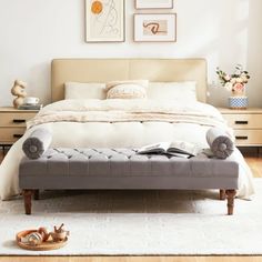 a bedroom with a bed, dressers and pictures on the wall