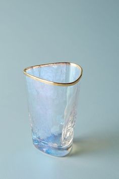 a blue glass with gold rim sitting on top of a white countertop next to a gray wall