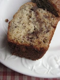 two slices of banana bread on a white plate with a red and white checkered tablecloth