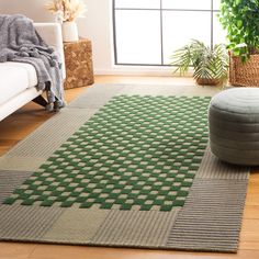 a living room with a couch, chair and large rugs on the hardwood floor