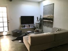 a living room filled with furniture and a flat screen tv mounted on the wall above it