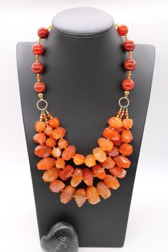 Orange Bead Necklace, Orange Statement Necklace, Carnelian Necklace, Carnelian Jewelry, Jewelry, Gifts, Beaded Necklace This is a stunner! This 3-tier rough cut orange Carnelian necklace is a bold handmade statement piece.  This necklace can be worn as a bright accent with a casual outfit or a focal piece to your evening wear.  The Carnelian beads range in size from 19mm to 23mm long.  The round Carnelian beads are 14mm. The twisted gold-plated connector ring is 12mm.  4mm Swarovski crystal spac Hand-strung Orange Beaded Necklace, Cheap Vintage Orange Necklaces, Cheap Orange Necklaces With Letter Beads, Luxury Gold Carnelian Beaded Necklaces, Orange Agate Gemstone Necklace, Red Faceted Carnelian Necklaces, Amber Carnelian Necklaces With Natural Stones, Orange Polished Beads Necklaces For Jewelry Making, Orange Carnelian Polished Beads Necklace