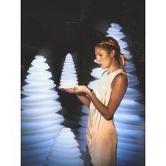 a woman standing in front of an illuminated fountain