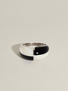 A new iteration of our beloved Form Ring incorporates inky black Onyx and iridescent white Mother of Pearl, inlaid in quadrants and framed in sterling silver or 14k gold. Billowing yet structured, these pieces take cues from avant proportion, exploring how graceful softness can be found within precise form.Measures approximately 10 mm in the front, tapering to 3 mm in the back. Solid 14k gold or sterling silver ring with a nice weight to it. Not quite sure of your ring size? To get the best fit Modern Black Enamel Ring Jewelry, Modern Black Enamel Ring, Modern Black Enamel Open Ring Jewelry, Modern White Gold Rings With Black Enamel, Modern Jewelry Ring With Polished Edges, Modern Oval Jewelry With Polished Edges, Modern Black Enamel Jewelry, Modern White Dome Ring, Modern Sterling Silver Jewelry With Black Enamel