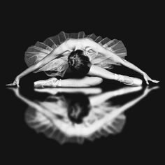 black and white photograph of a ballerina in tutu with reflection on the floor