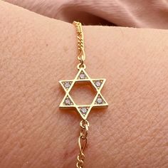 A beautiful and dainty Goldfilled Star of David bracelet. The chain is goldfield and the Magen David is Gold plated with high-quality 2-micron gold. This Jewish star bracelet comes wrapped in an excellent package and is ready to give as a Judaica Jewelry gift or Bat Mitzvah gift. ❤𝗠𝗘𝗔𝗦𝗨𝗥𝗘𝗠𝗘𝗡𝗧𝗦 ❤ Pendant with: 0.39" /1 cm Please choose your length from the drop-down list. ❤ 𝗠𝗬 𝗦𝗧𝗢𝗥𝗘 ❤ For more bracelets : https://etsy.me/3hhni0o Back to my shop:  https://etsy.me/2ZBJCus ❤ 𝗔𝗕? Adjustable Gold Star Of David Jewelry, Gold Chain Bracelet With Adjustable Chain For Spiritual Wear, Hannukah Gifts, Hannukah Gift, Jewish Star Necklace, Judaica Jewelry, Jewish Star, Bat Mitzvah Gifts, Jewish Jewelry