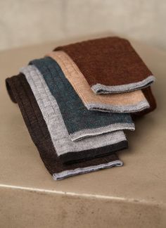 three folded towels sitting on top of a counter next to each other in different colors