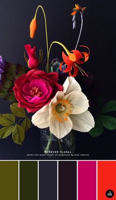 a vase filled with flowers on top of a black table next to color swatches