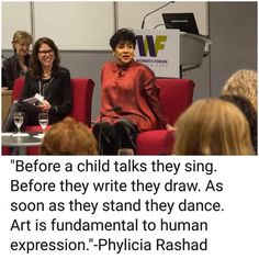 two women sitting on red chairs in front of a microphone with the caption before a child talks they sing before they write they draw as soon as they stand