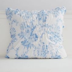 a blue and white pillow sitting on top of a bed