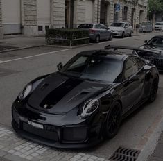 a black sports car is parked on the street