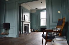 an empty living room with blue walls and wood floors