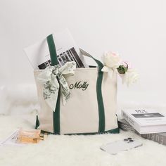 a white bag sitting on top of a furry floor next to a pile of books